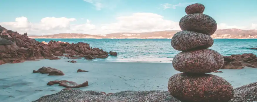 Stones balanced on top of each other on the beach.